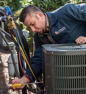 Technician repairing outdoor AC unit