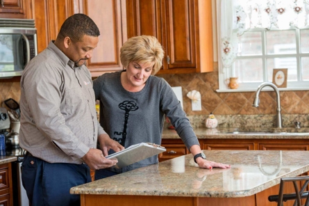 Technician going over information with homeowner in the kitchen