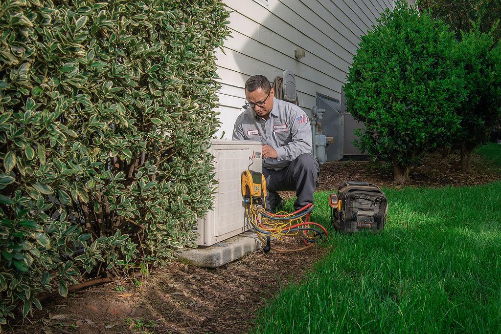Man working on outdoor HVAC unit