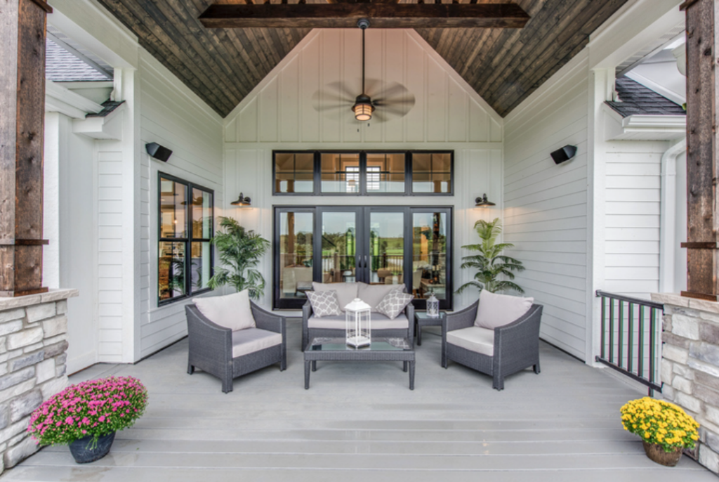 Modern porch with a fan, furniture, and potted plants
