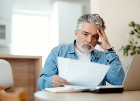 A homeowner looking at a utility bill with a concerned, overwhelmed look on their face